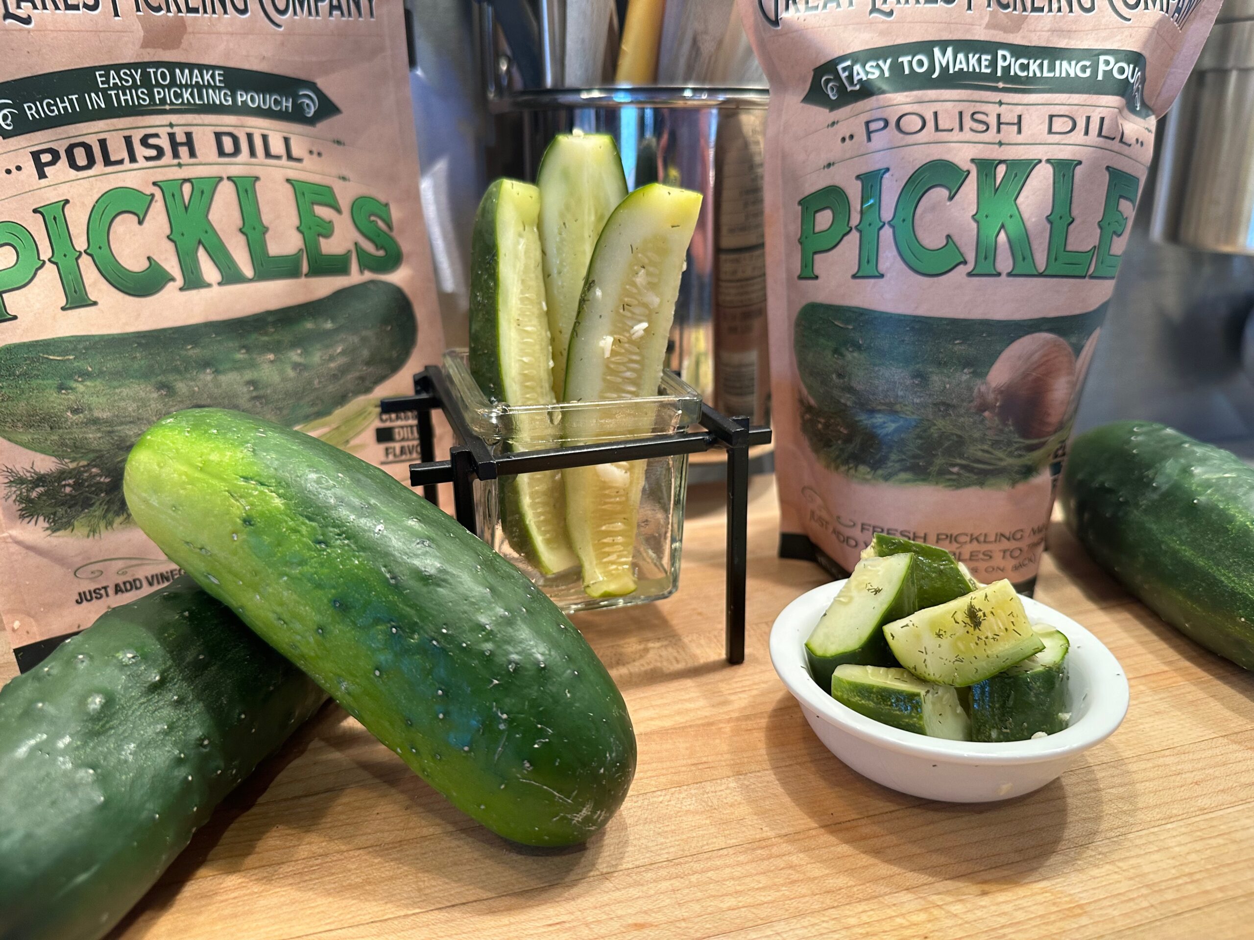 Kirby cucumbers on a cutting board, cut into spears and cut into wedges to be pickled in a pickling pouch